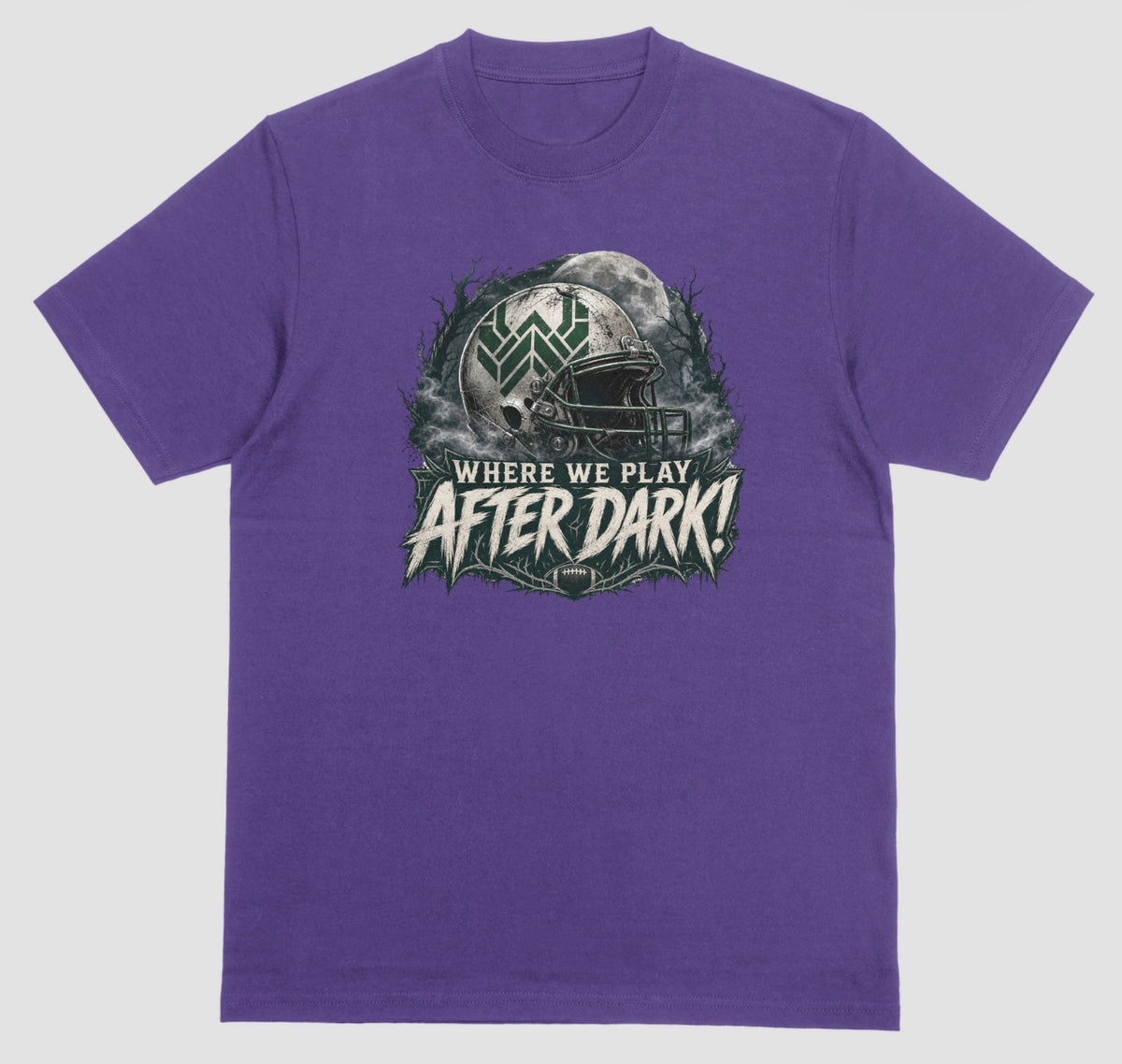 A purple t-shirt with a spooky football graphic reading 'Where We Play After Dark!' showing a weathered white helmet with a green 'W' logo in front of a full moon.