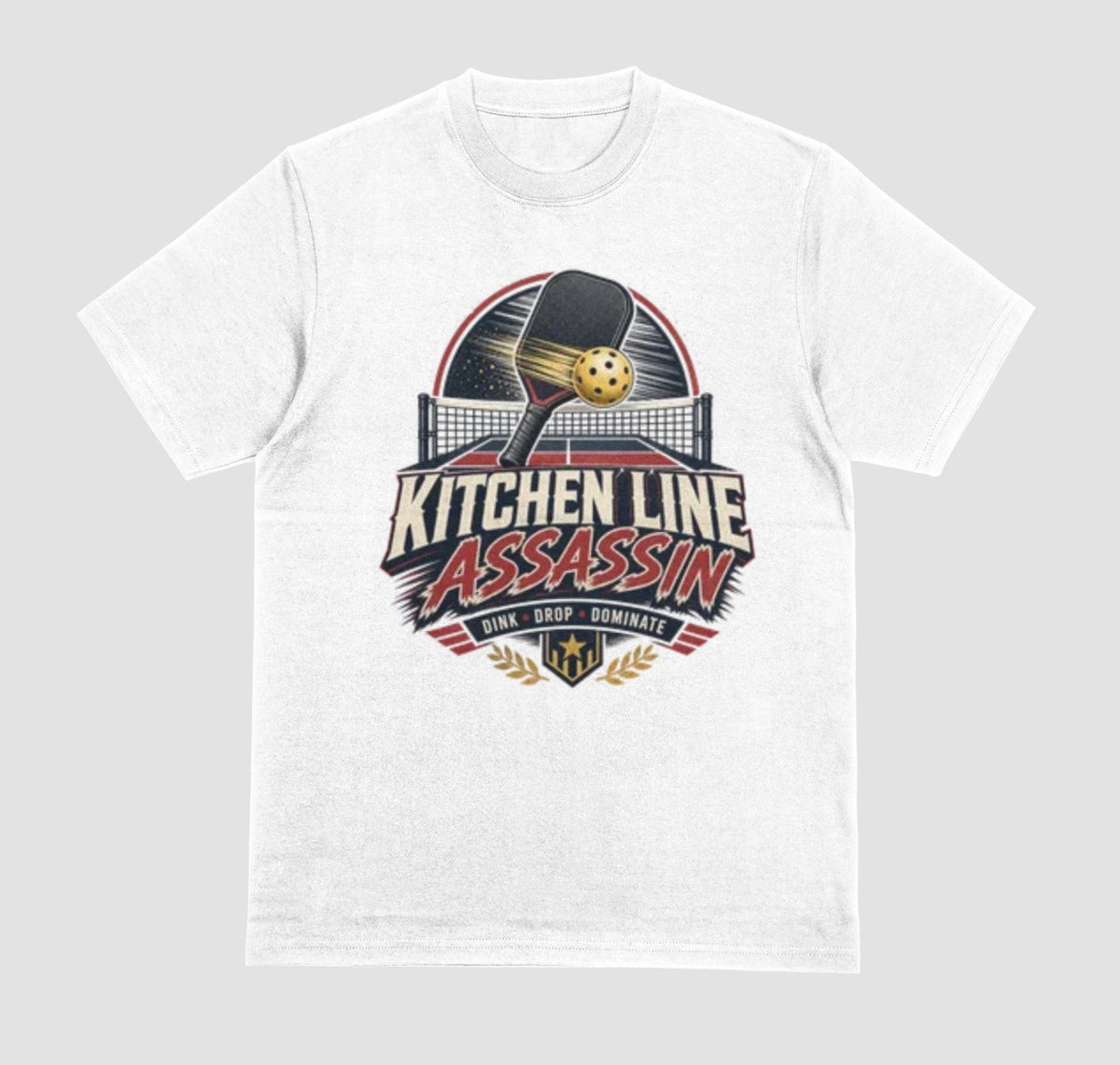 a white crewneck t-shirt featuring a graphic print on the front with a pickleball paddle and ball above the text 'KITCHEN LINE ASSASSIN' and 'DINK - DROP - DOMINATE'.