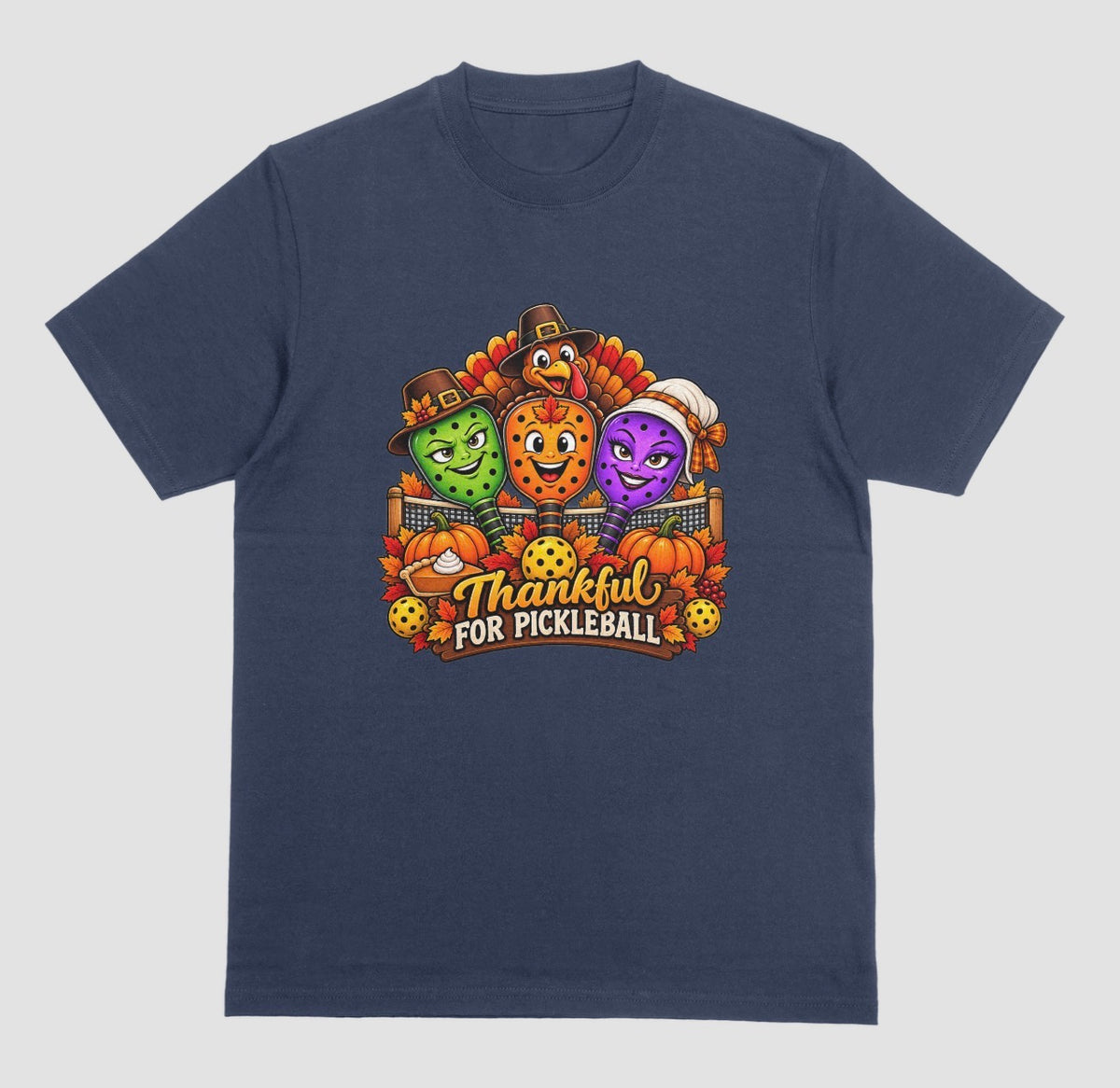 A navy blue t-shirt with “Thankful for Pickleball” design of three pilgrim-hat paddles, a turkey, pumpkins, and pie