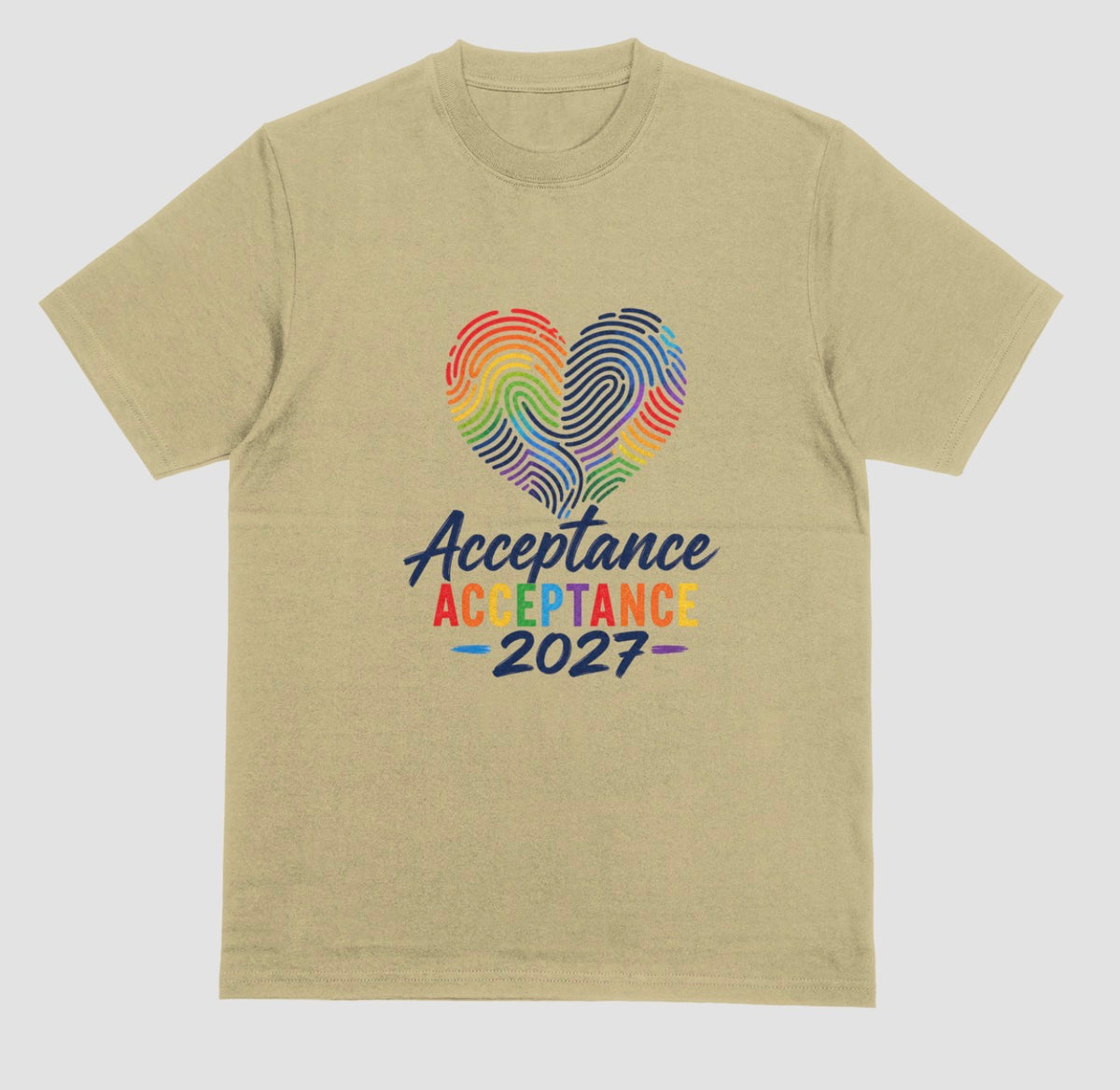 A sand crewneck t-shirt featuring a graphic on the front with a rainbow-striped heart made of fingerprint patterns and the text 'Acceptance 2027' in dark blue and rainbow colors.