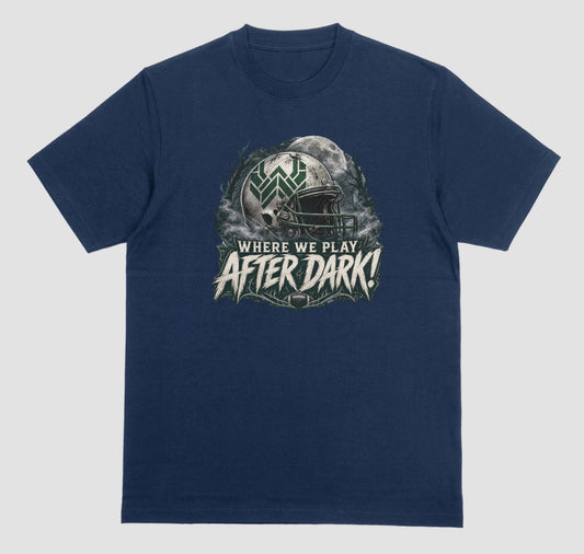 A midnight t-shirt with a spooky football graphic reading 'Where We Play After Dark!' showing a weathered white helmet with a green 'W' logo in front of a full moon.