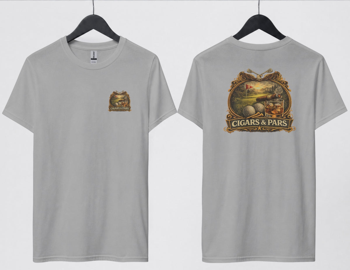 A grey t-shirt, front and back views on hangers. Front features a small crest-style graphic on the left chest with a golf course scene, crossed clubs, golf balls, and a cigar, framed above a banner reading 'Cigars & Pars.' Back features the same design enlarged: an eagle with crossed golf clubs above an oval scene of a golf green with a flag reading '9,' bordered below by golf balls, tees, a cigar, and a whiskey glass with ice, all above a decorative banner reading 'Cigars & Pars' with a star."