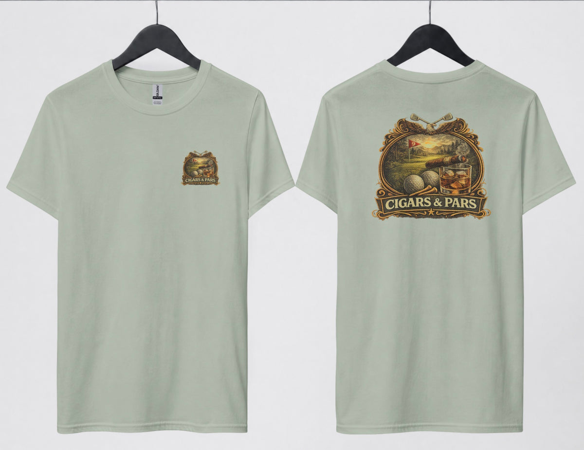 A sage green t-shirt, front and back views on hangers. Front features a small crest-style graphic on the left chest with a golf course scene, crossed clubs, golf balls, and a cigar, framed above a banner reading 'Cigars & Pars.' Back features the same design enlarged: an eagle with crossed golf clubs above an oval scene of a golf green with a flag reading '9,' bordered below by golf balls, tees, a cigar, and a whiskey glass with ice, all above a decorative banner reading 'Cigars & Pars' with a star."