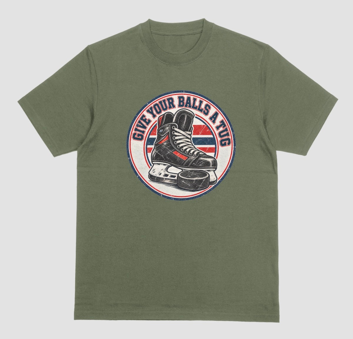 A military green t-shirt with a round vintage crest reading 'Give Your Balls a Tug' around a hockey skate and puck in red, white, and blue.