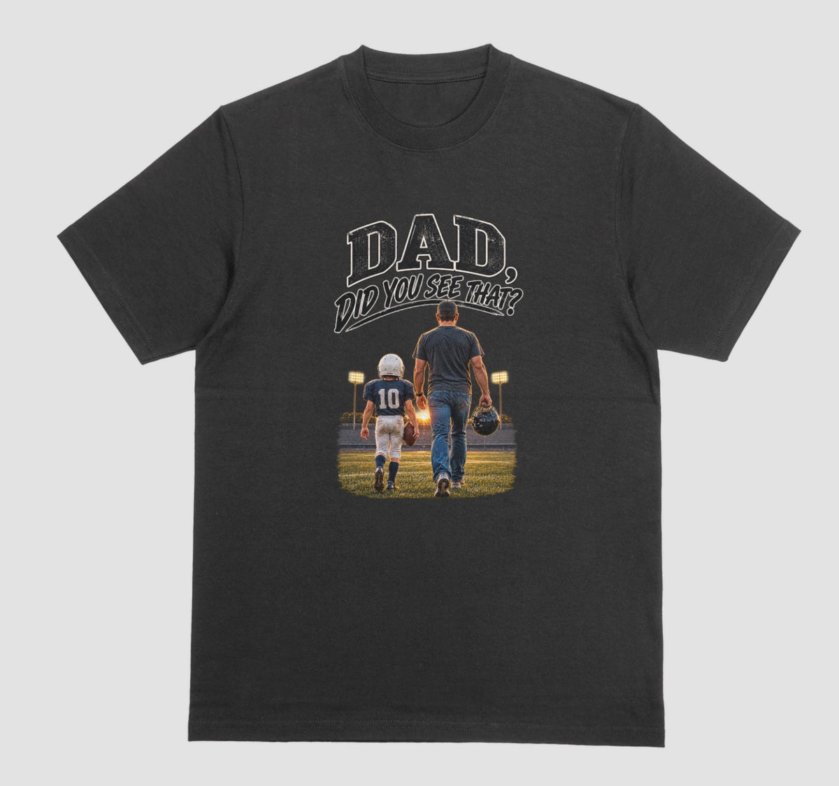 A black crewneck t-shirt featuring a graphic print on the front. The graphic shows a father and son walking on a football field at night, with the text 'DAD DID YOU SEE THAT?' above them.