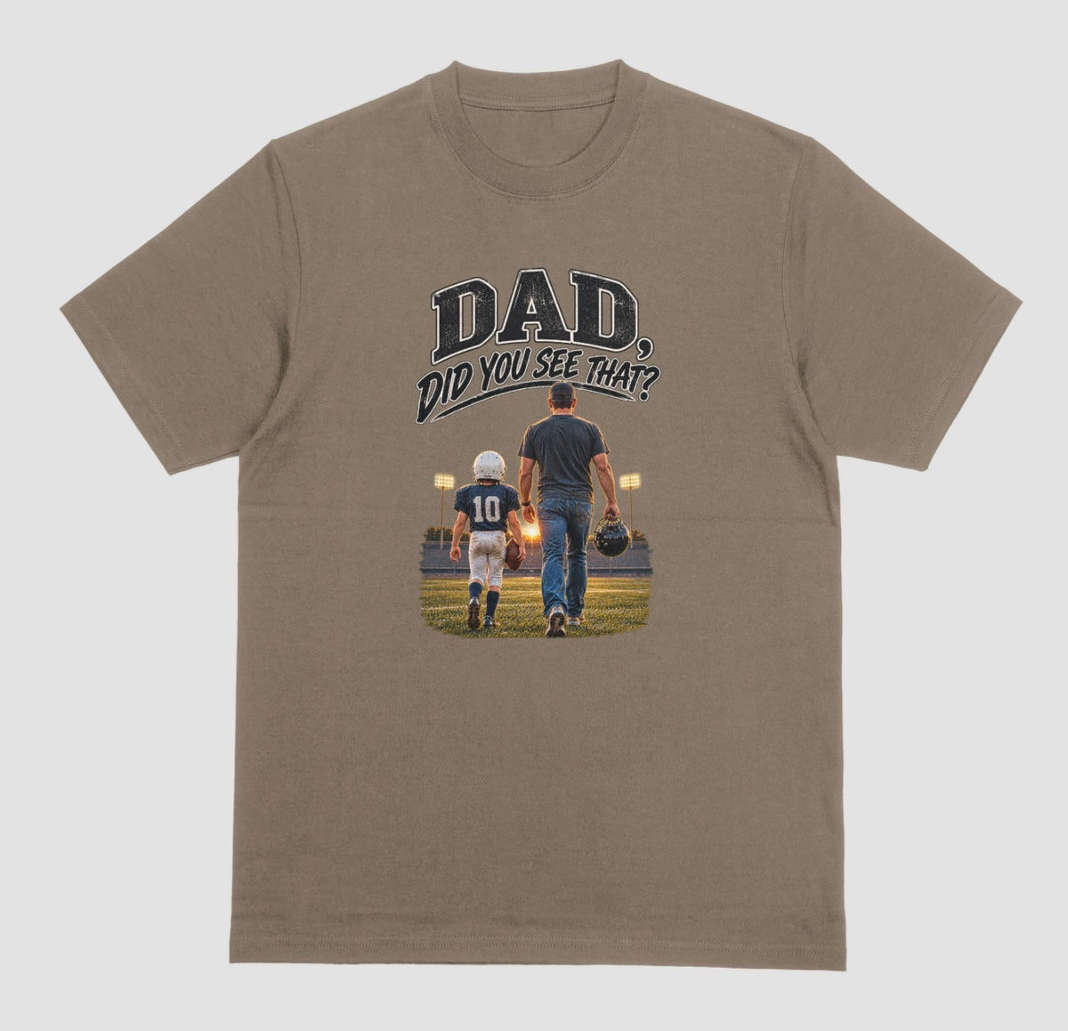 A brown savana crewneck t-shirt featuring a graphic print on the front. The graphic shows a father and son walking on a football field at night, with the text 'DAD DID YOU SEE THAT?' above them.