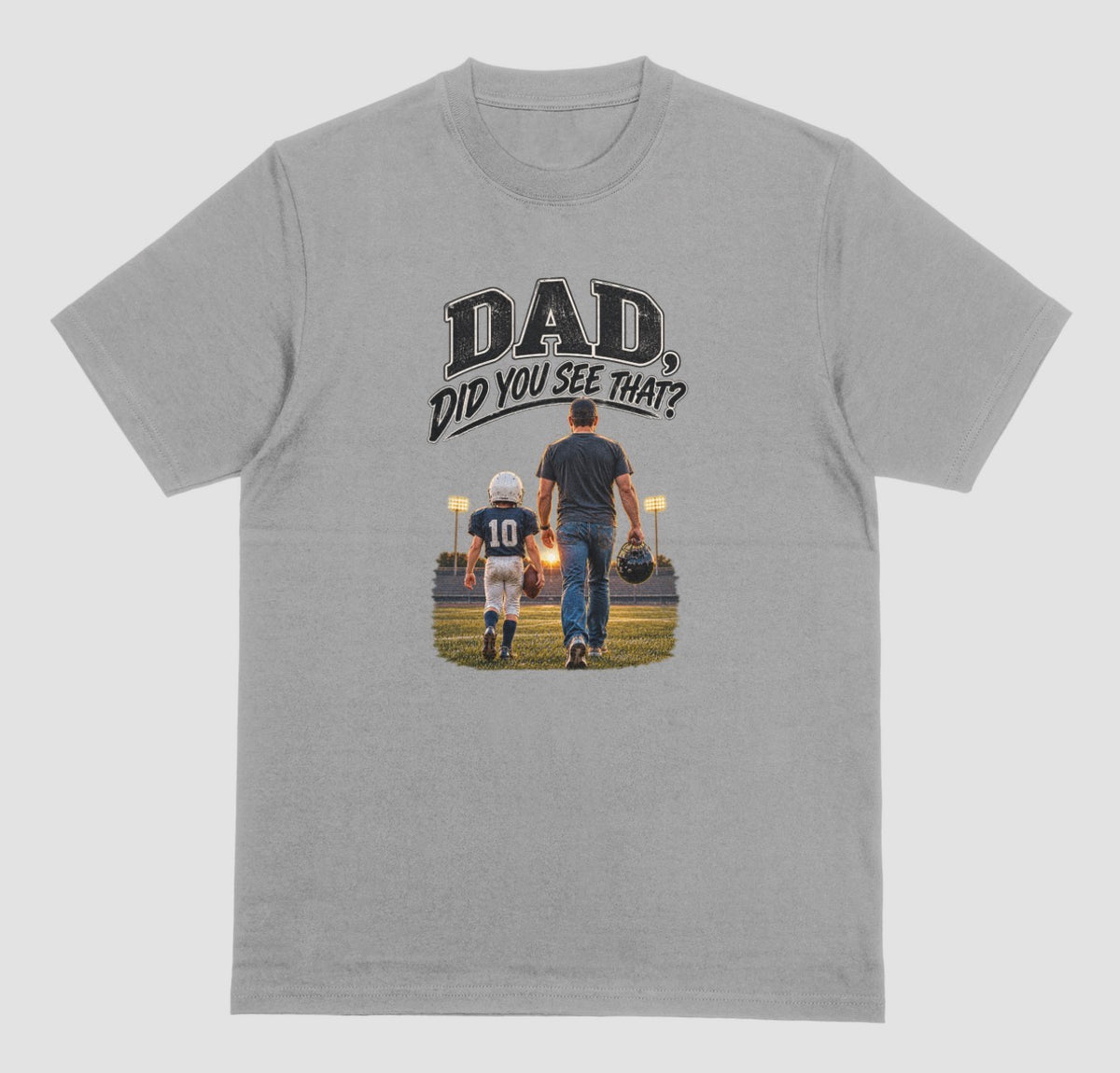 A grey crewneck t-shirt featuring a graphic print on the front. The graphic shows a father and son walking on a football field at night, with the text 'DAD DID YOU SEE THAT?' above them.