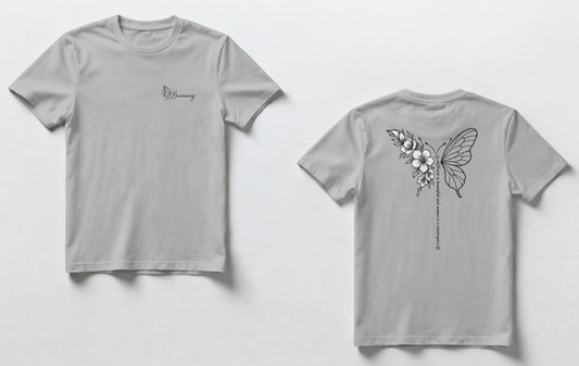 “Two gray t-shirts shown side by side. The front has a small script logo on the chest, and the back has a black line-art butterfly with flowers and a vertical line of small text.”