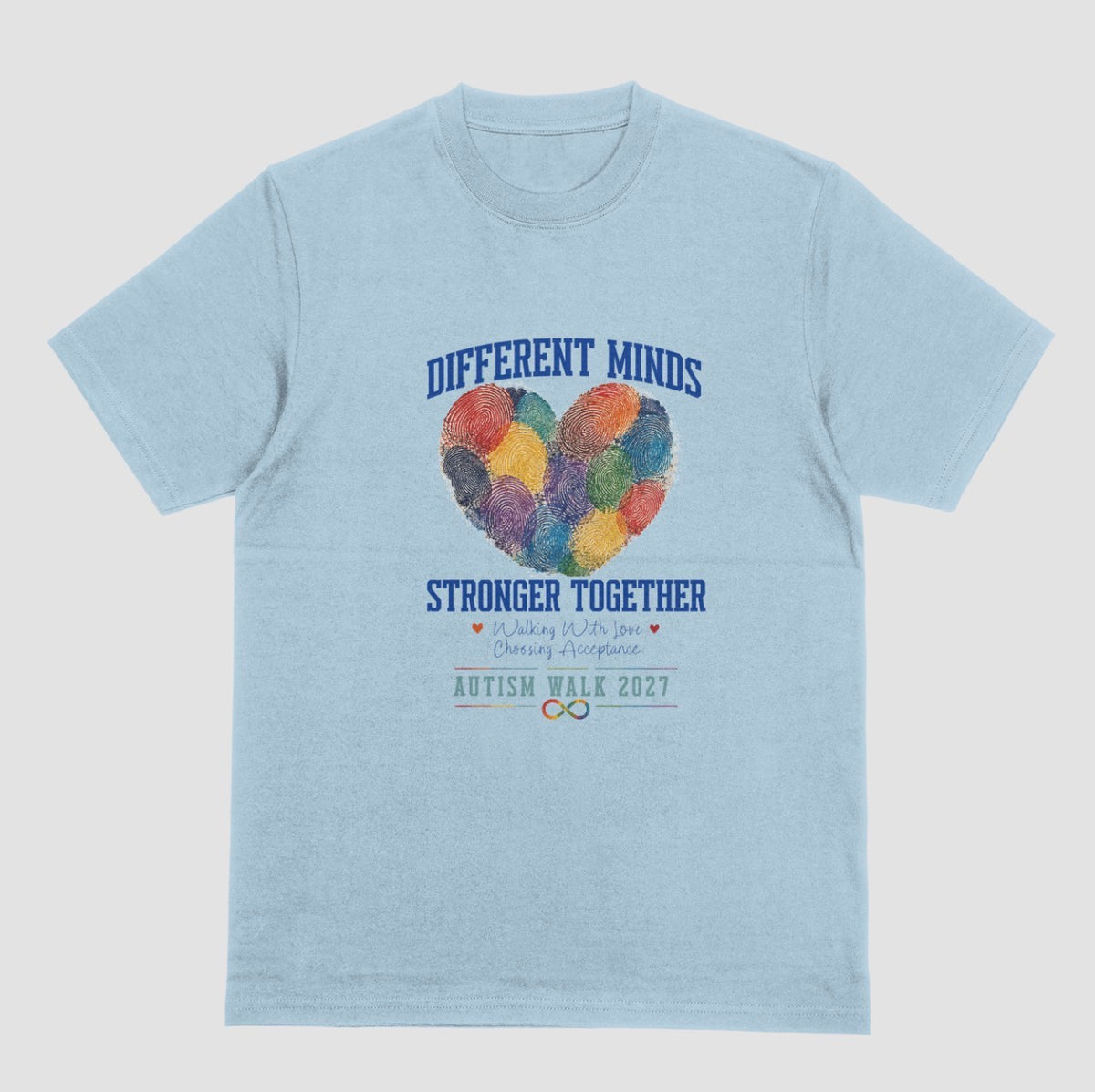 A light blue crewneck t-shirt featuring a graphic design for the 'Autism Walk 2027'. The design includes the text 'DIFFERENT MINDS STRONGER TOGETHER' in blue, a heart made of colorful fingerprint patterns in the center, and the 'Autism Walk 2027' logo at the bottom.