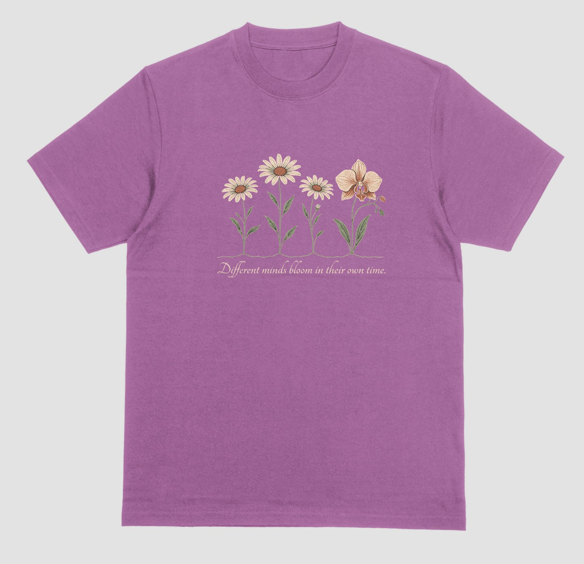 A light orchid t-shirt with an illustration of three daisies and an orchid and the script text ‘Different minds bloom in their own time.’