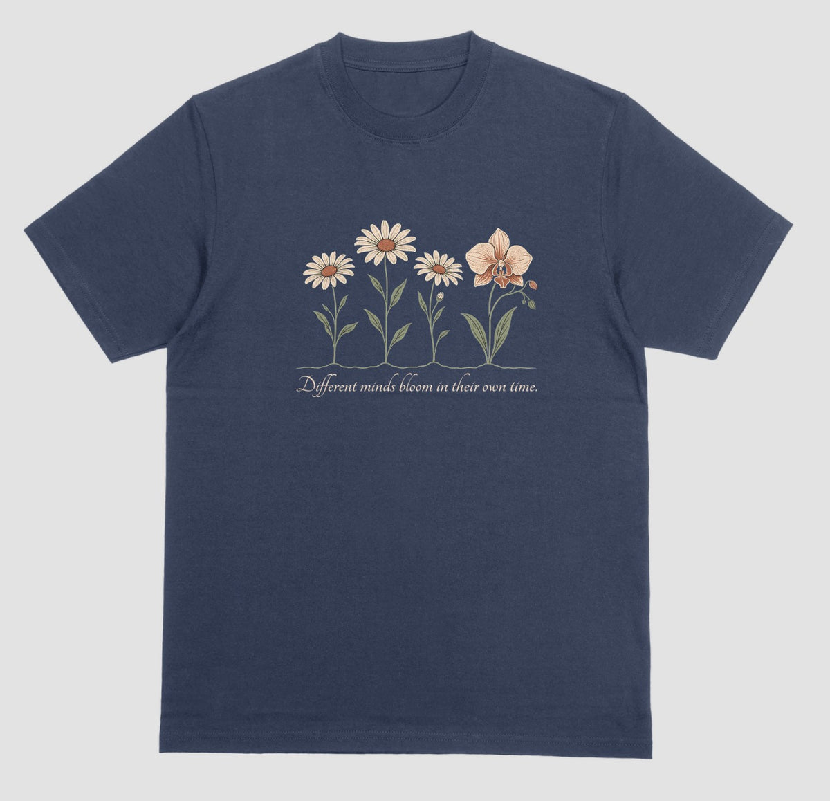 A navy blue t-shirt with an illustration of three daisies and an orchid and the script text ‘Different minds bloom in their own time.’