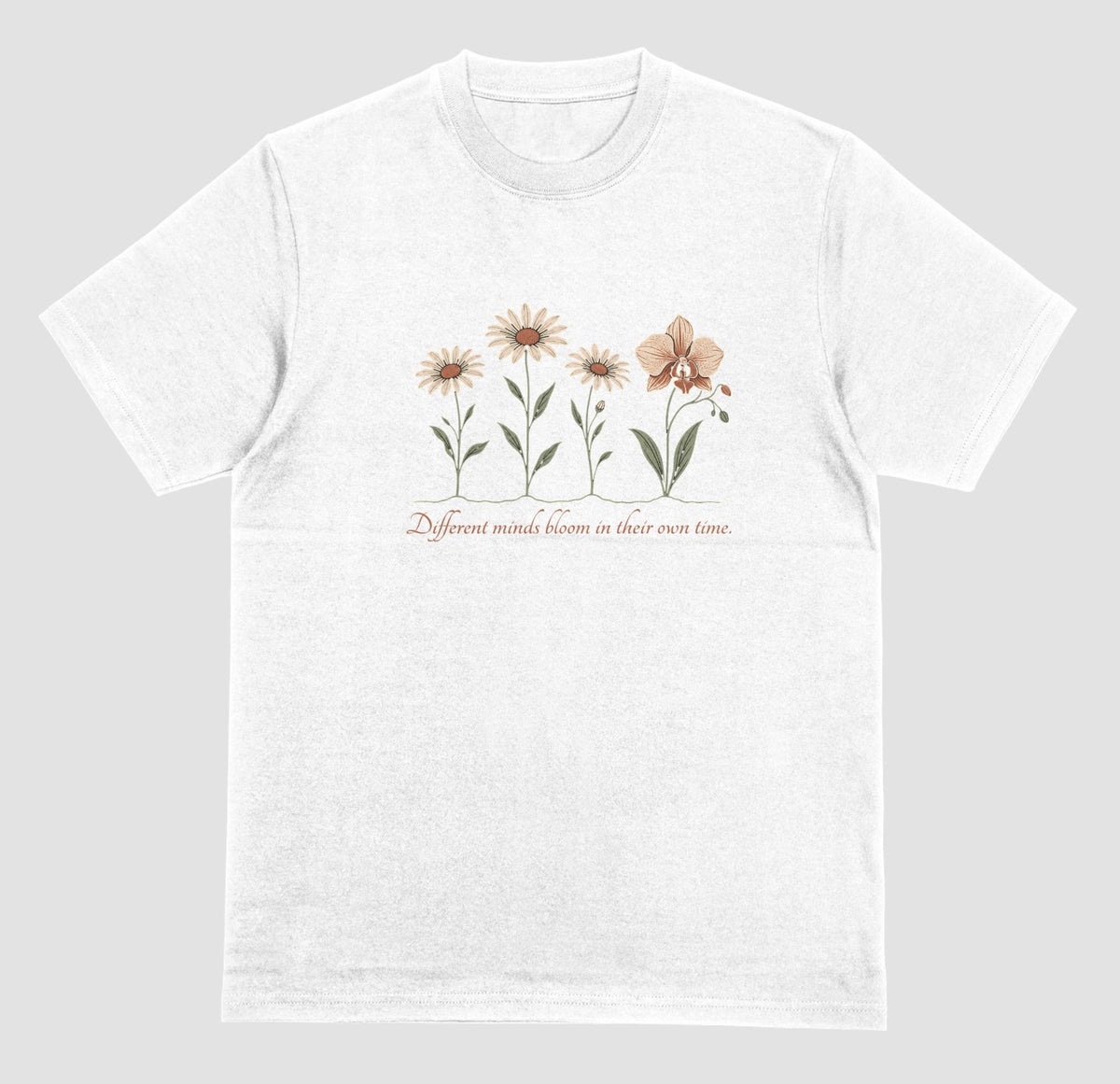 A white t-shirt with an illustration of three daisies and an orchid and the script text ‘Different minds bloom in their own time.’