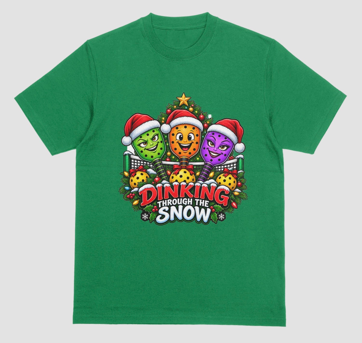 Green t-shirt with “Dinking Through the Snow” Christmas design featuring pickleball paddles in Santa hats