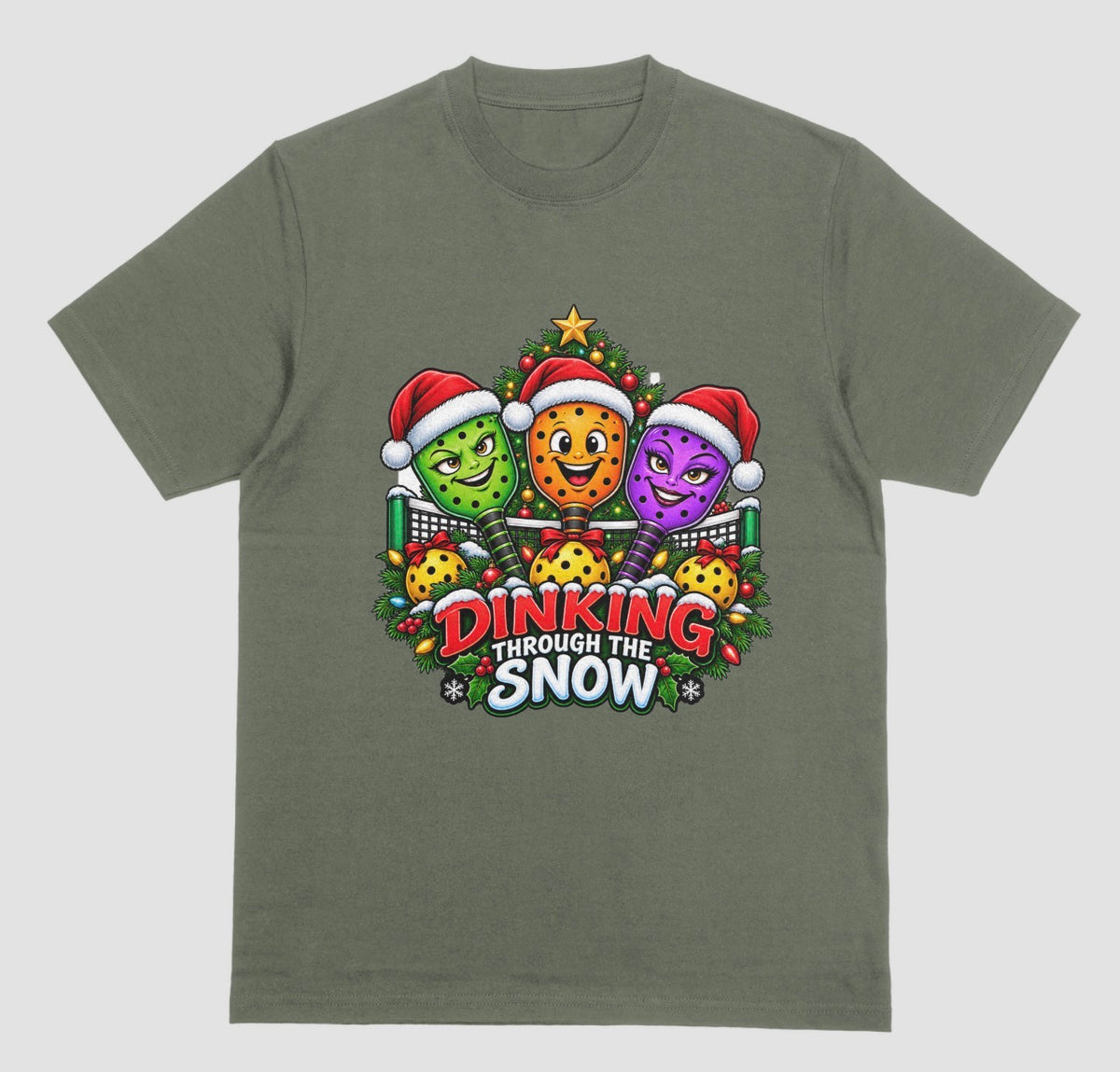 A military green t-shirt with “Dinking Through the Snow” Christmas design featuring pickleball paddles in Santa hats
