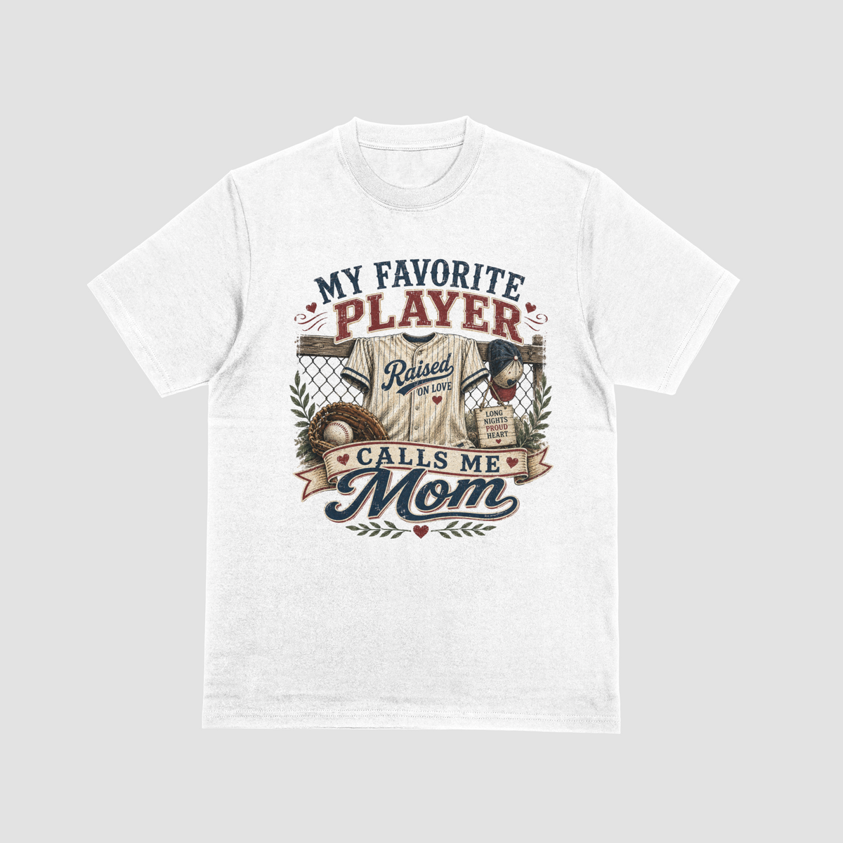 A white short-sleeve crewneck t-shirt featuring a baseball-themed graphic with a jersey, glove, and baseball, and the text “MY FAVORITE PLAYER CALLS ME MOM.”