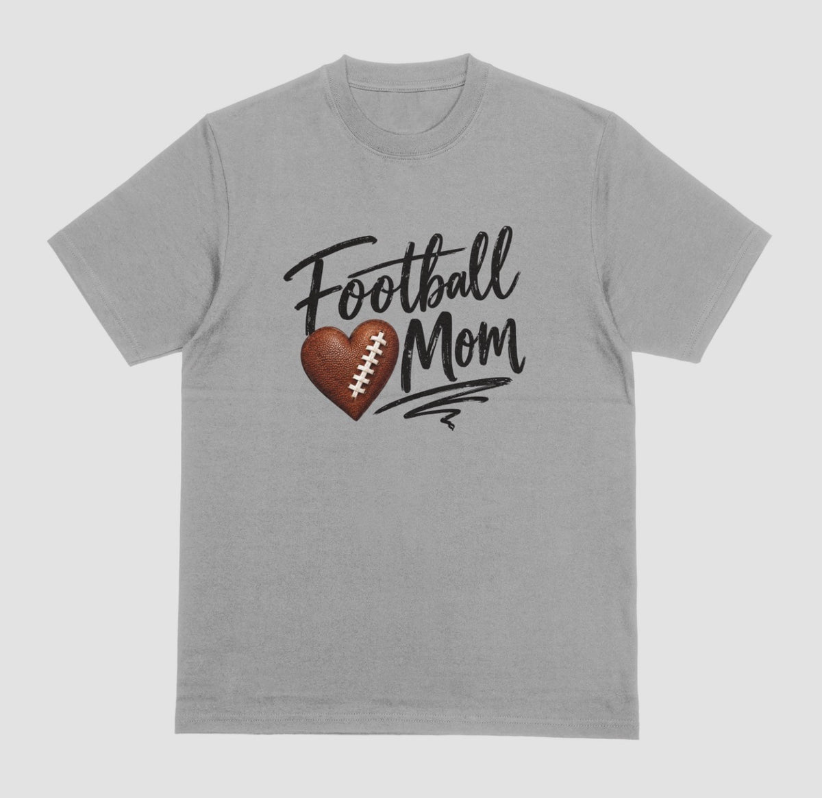 A grey crewneck T-shirt featuring 'Football Mom' text in black script lettering, with a football-textured heart design between the words