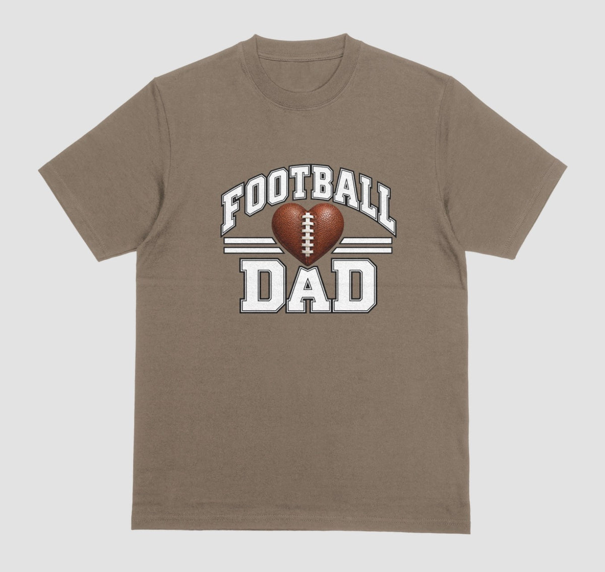 A brown savana short-sleeve t-shirt with a 'FOOTBALL DAD' graphic on the chest. The graphic features a brown heart-shaped football in the center, flanked by two white horizontal stripes, with 'FOOTBALL' arched above and 'DAD' printed below in a distressed white font.