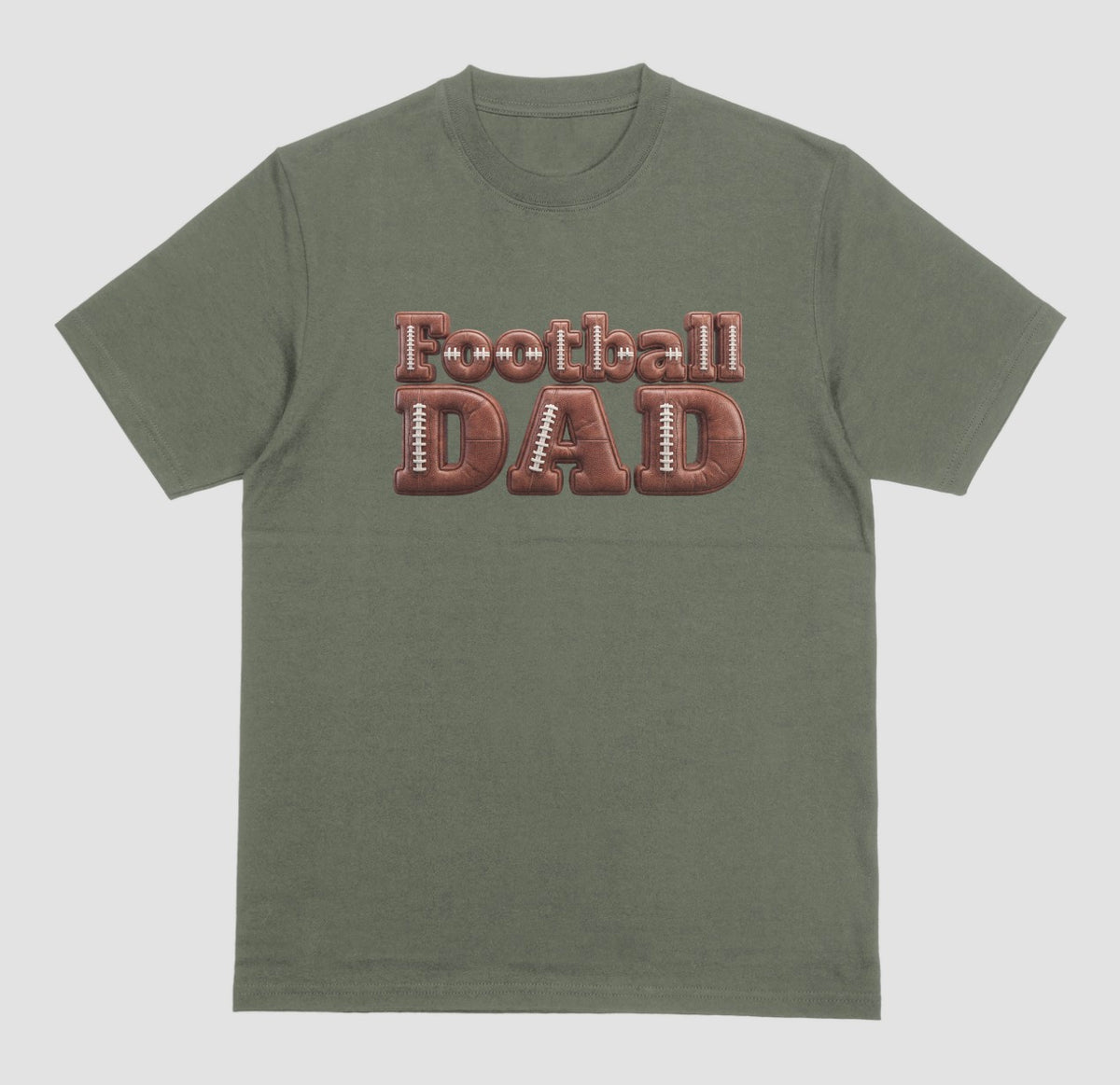 A military green crewneck t-shirt featuring a graphic on the chest that reads 'Football DAD' in a 3D block font filled with a brown football leather texture and white laces.