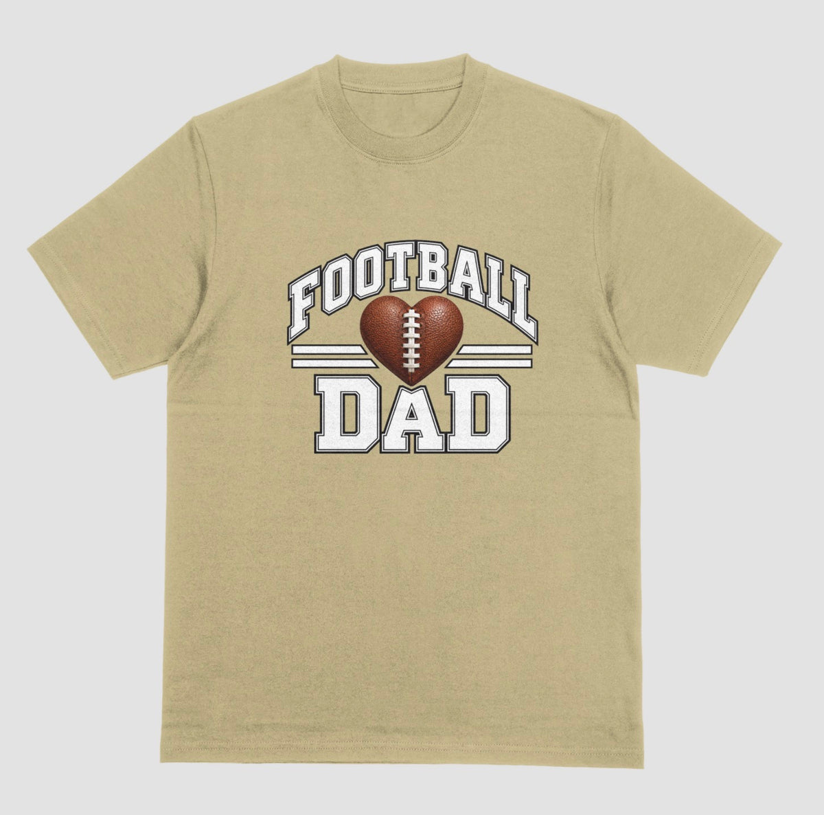 A sand color short-sleeve t-shirt with a 'FOOTBALL DAD' graphic on the chest. The graphic features a brown heart-shaped football in the center, flanked by two white horizontal stripes, with 'FOOTBALL' arched above and 'DAD' printed below in a distressed white font.