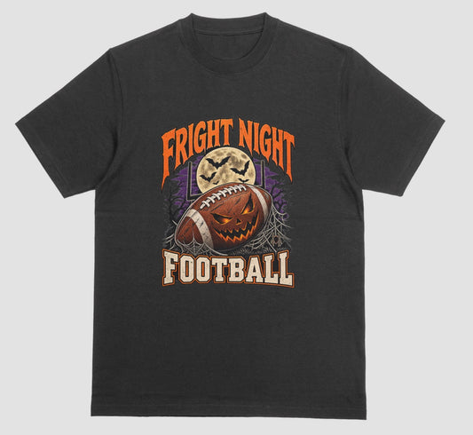 Black t-shirt reading "Fright Night Football" in orange and cream lettering, with a jack-o'-lantern football in front of a full moon, bats, and goalposts