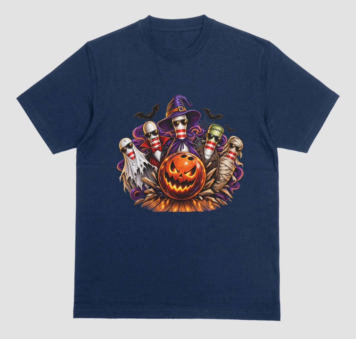 A Midnight blue Halloween bowling t-shirt featuring a graphic of five bowling pins dressed as a ghost, vampire, witch, Frankenstein's monster, and mummy, all wearing sunglasses, behind a glowing jack-o'-lantern bowling ball