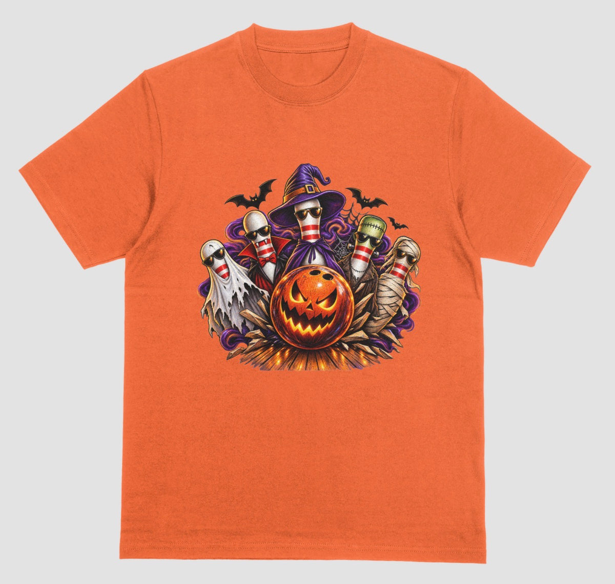An orange Halloween bowling t-shirt featuring a graphic of five bowling pins dressed as a ghost, vampire, witch, Frankenstein's monster, and mummy, all wearing sunglasses, behind a glowing jack-o'-lantern bowling ball