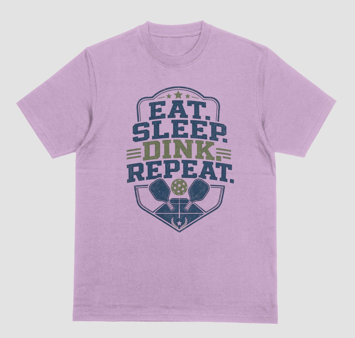 A lilac crewneck t-shirt featuring a distressed graphic on the front with the text 'EAT. SLEEP. DINK. REPEAT.'
