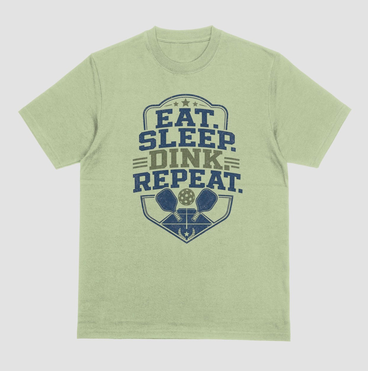A pistachio green crewneck t-shirt featuring a distressed graphic on the front with the text 'EAT. SLEEP. DINK. REPEAT.'