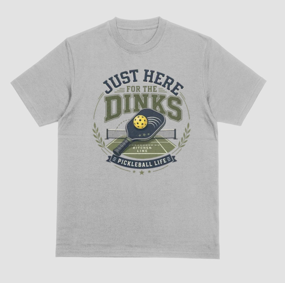 A gray t-shirt with a vintage-style graphic on the chest that reads 'JUST HERE FOR THE DINKS' and 'PICKLEBALL LIFE!' around an illustration of a paddle, ball, and court.
