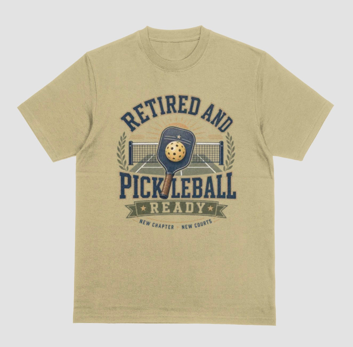 A sand color crewneck t-shirt with the saying 'RETIRED AND PICKLEBALL READY' with a pickleball and paddle displayed with a vintage style.