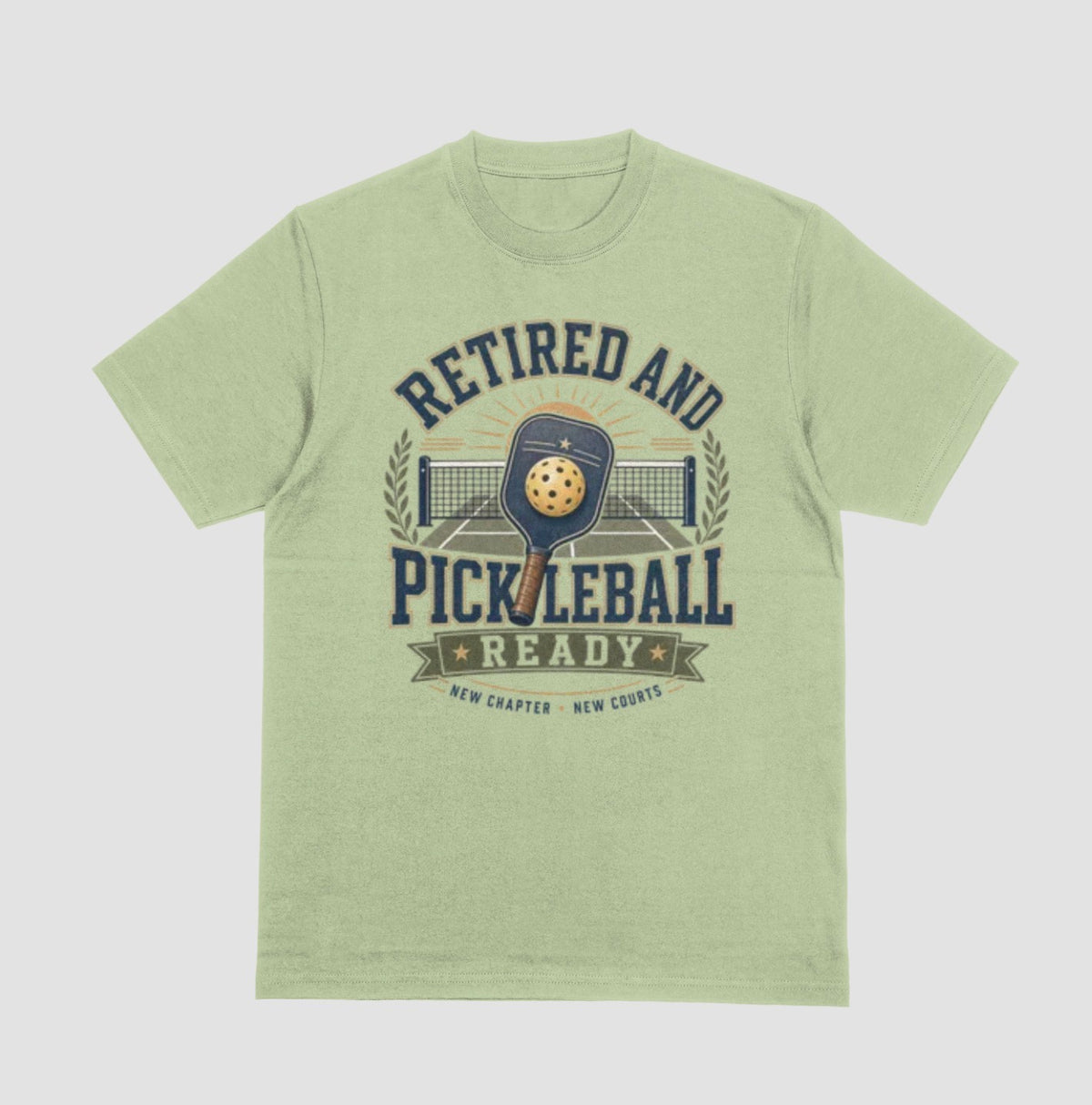 A pistachio green crewneck t-shirt with the saying 'RETIRED AND PICKLEBALL READY' with a pickleball and paddle displayed with a vintage style.