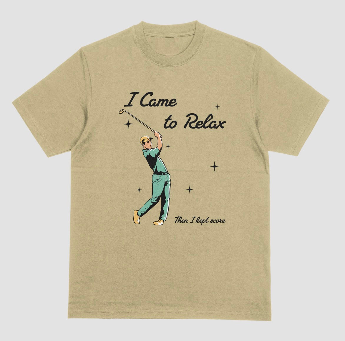 A sand color crewneck t-shirt featuring a retro-style graphic of a golfer mid-swing with the text 'I Came to Relax' and 'Then, I kept score'.