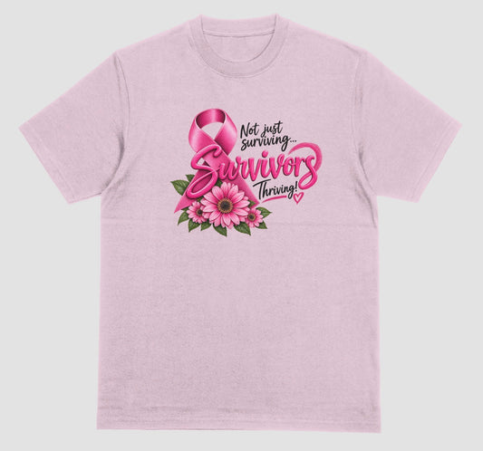 A light pink t-shirt with pink breast cancer awareness ribbon, pink daisy flowers, and 'Not Just Surviving... Survivors Thriving!' quote in pink and black lettering