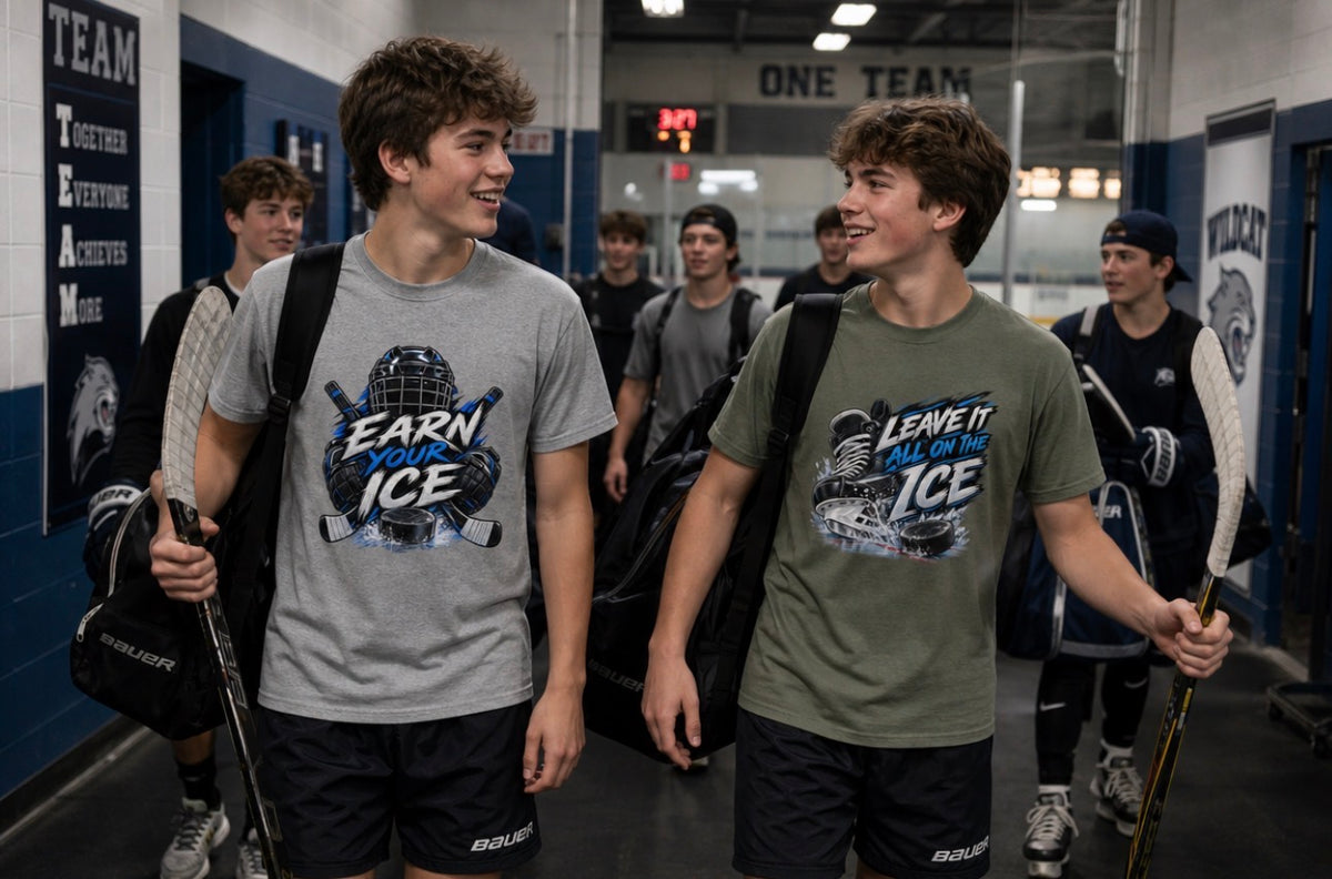 Two teen hockey players in a rink hallway wearing "Earn Your Ice" and "Leave It All on the Ice" graphic t-shirts, carrying sticks and gear bags