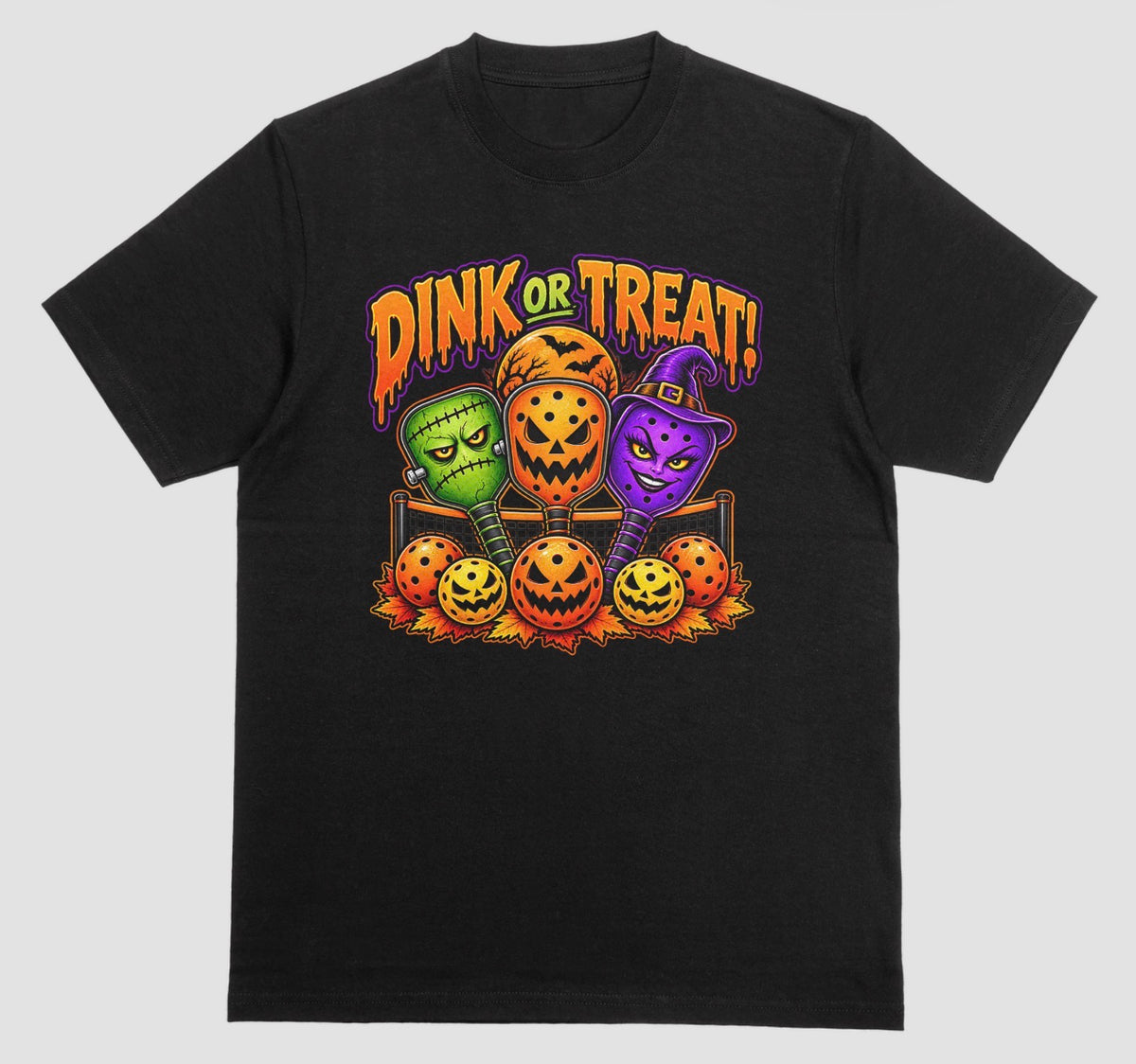 Black “Dink or Treat!” Halloween pickleball t-shirt with Frankenstein, pumpkin, and witch paddles