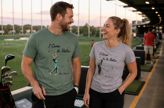 A man and a woman standing on a golf driving range, both wearing similar graphic t-shirts with a golfer illustration and the text 'I Came to Relax Then I kept score'.