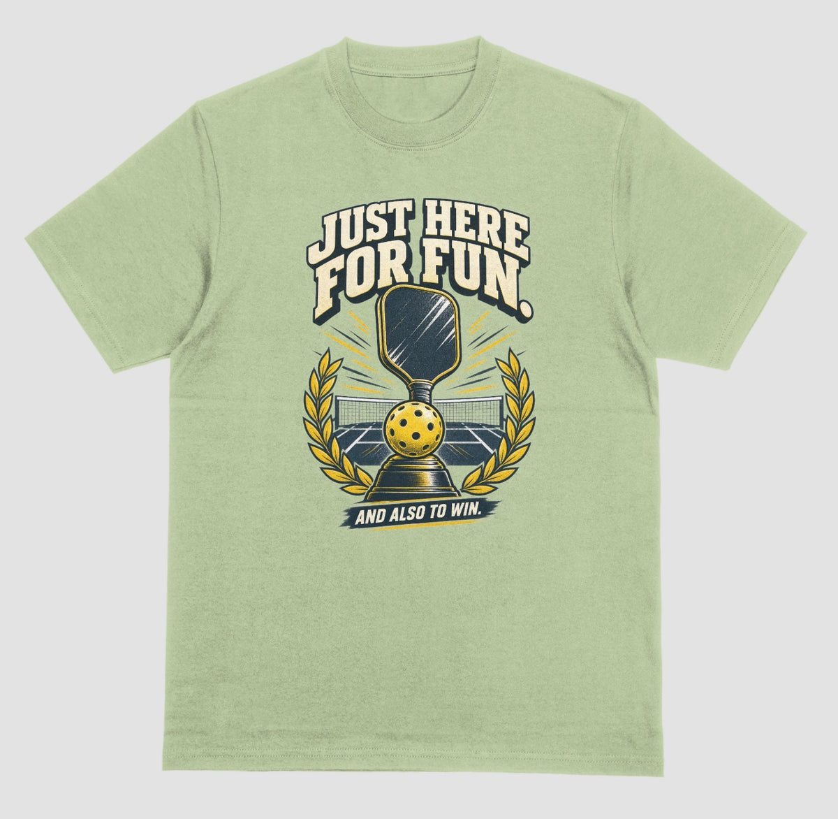 A light green Funny pickleball shirt with a trophy, paddle and laurel wreath design that says Just Here for Fun and Also to Win
