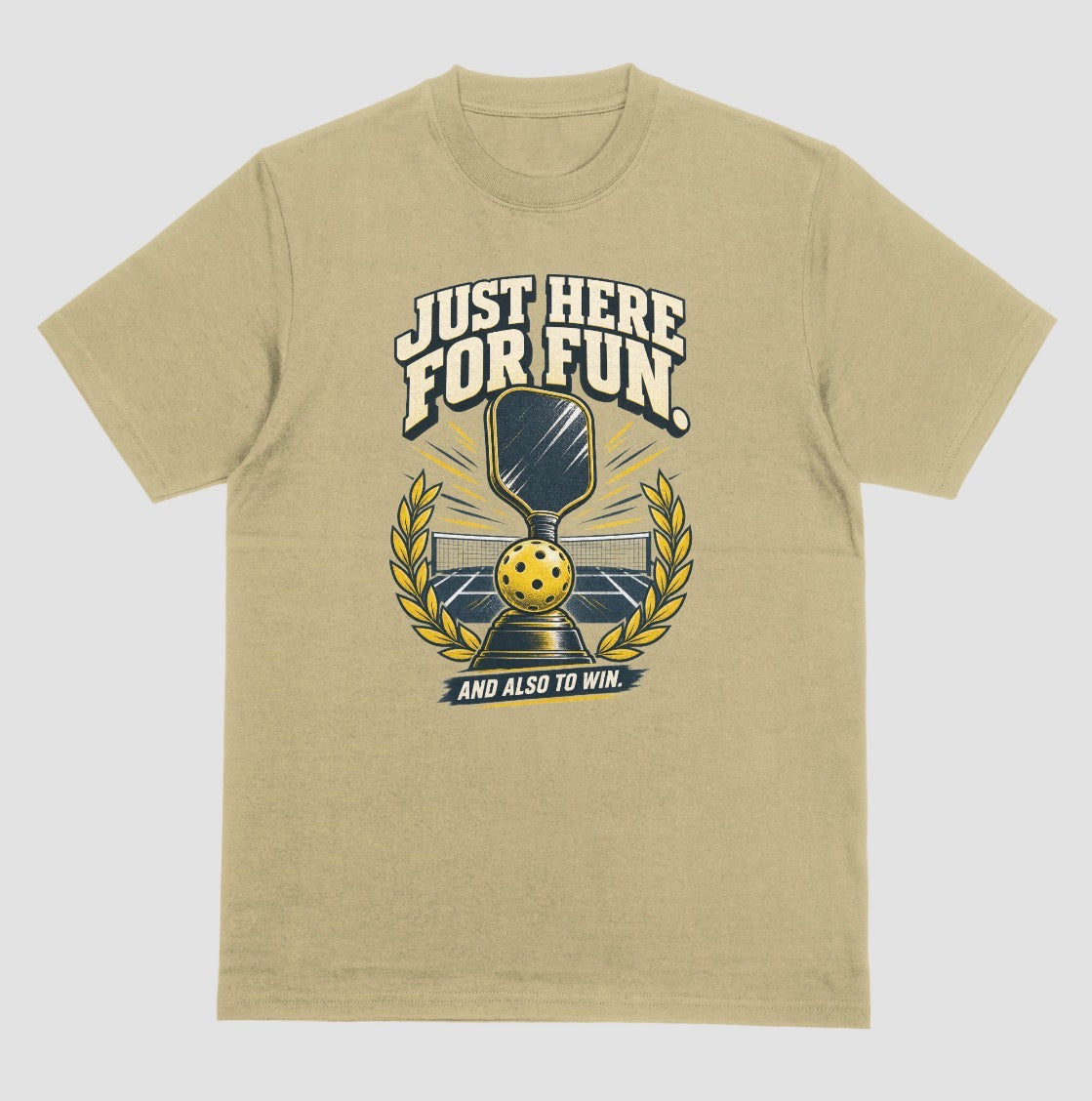 A sand color Funny pickleball shirt with a trophy, paddle and laurel wreath design that says Just Here for Fun and Also to Win