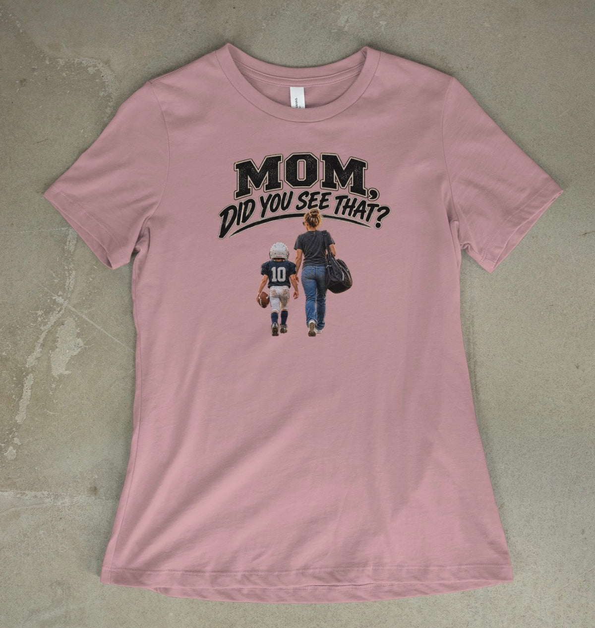 A pink gravel short-sleeve t-shirt with a graphic print on the front that reads 'MOM DID YOU SEE THAT?' above an illustration of a mother and child walking away, laid flat on a textured concrete surface.