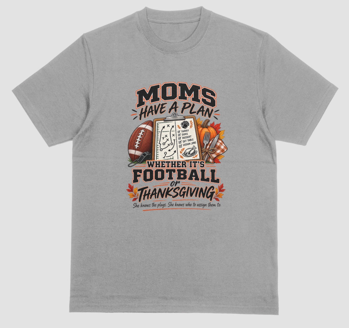 a grey t-shirt featuring 'Moms Have a Plan, Whether It's Football or Thanksgiving' quote with football, clipboard playbook, pumpkin, and turkey dinner graphics"