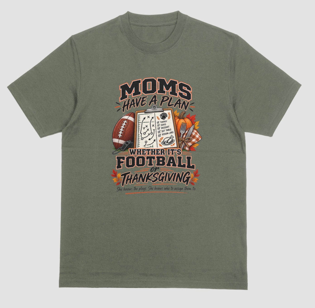 A military green t-shirt featuring 'Moms Have a Plan, Whether It's Football or Thanksgiving' quote with football, clipboard playbook, pumpkin, and turkey dinner graphics"