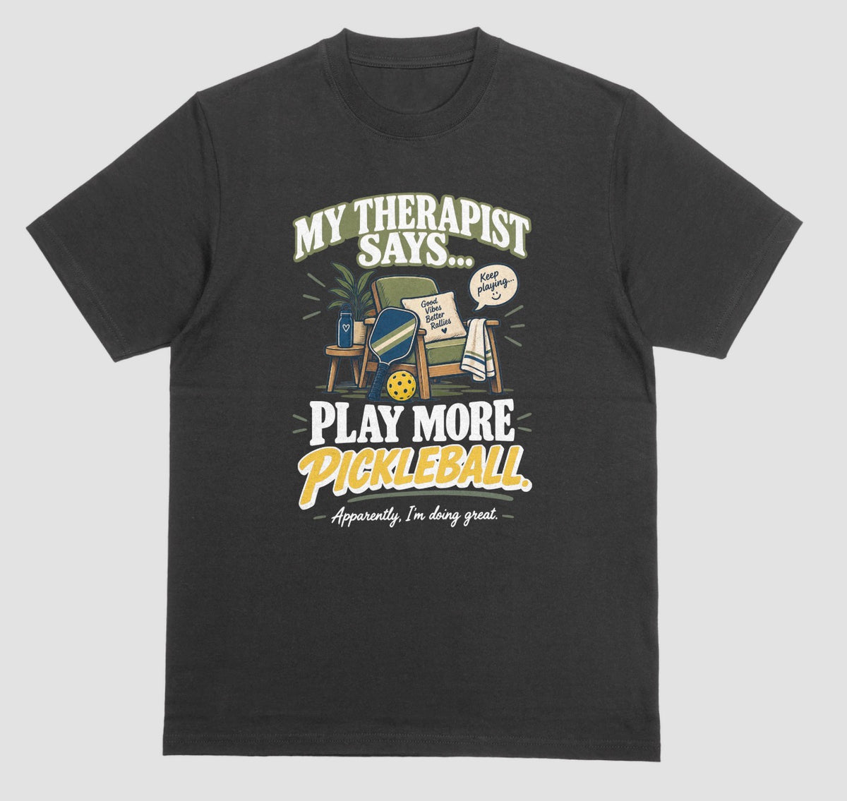 A black Funny pickleball shirt with an armchair and paddle design that says My Therapist Says Play More Pickleball