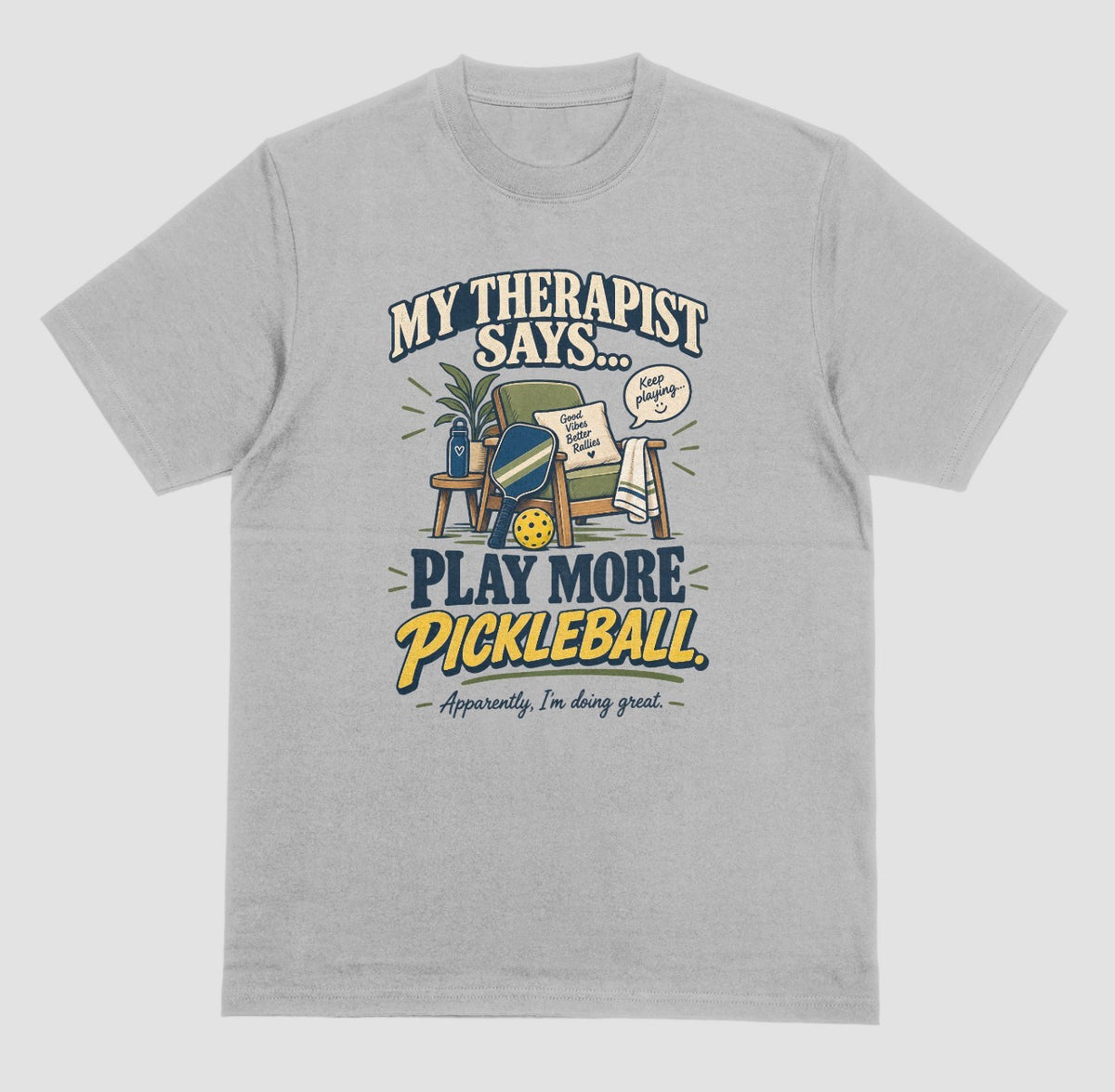 A grey Funny pickleball shirt with an armchair and paddle design that says My Therapist Says Play More Pickleball