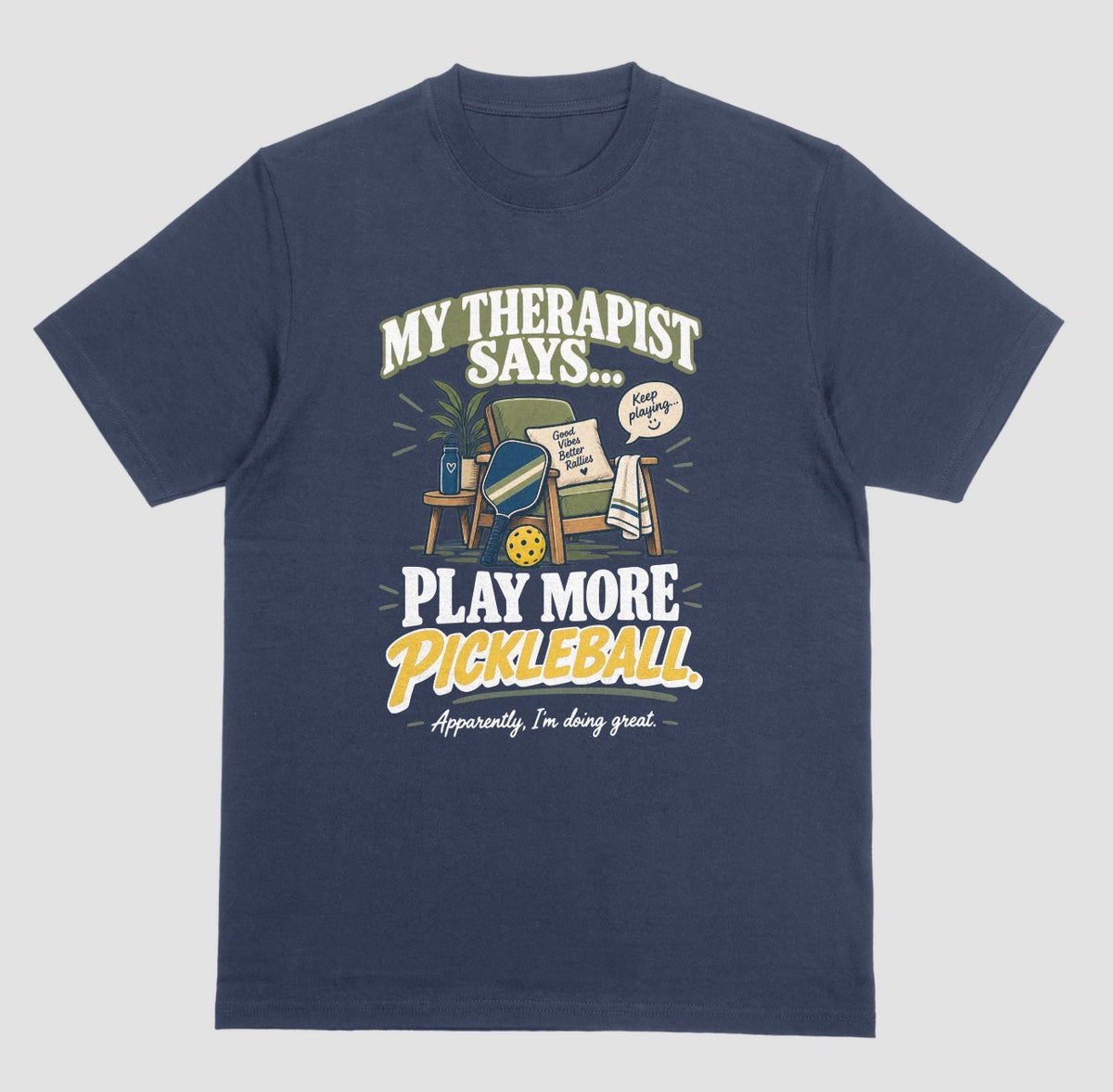 A navy blue Funny pickleball shirt with an armchair and paddle design that says My Therapist Says Play More Pickleball