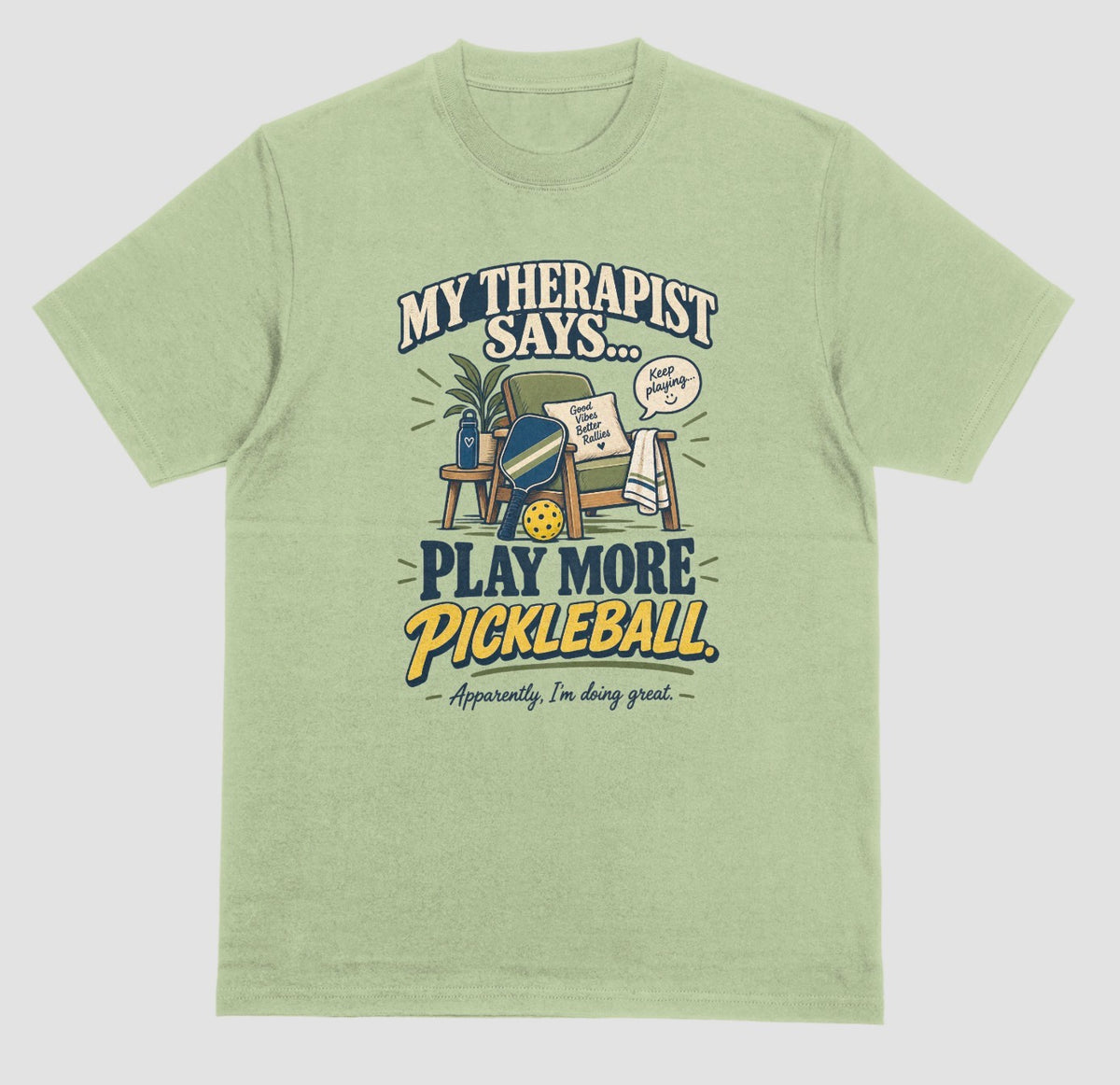 A light green Funny pickleball shirt with an armchair and paddle design that says My Therapist Says Play More Pickleball