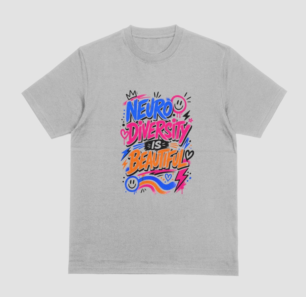 A grey short-sleeve crewneck t-shirt featuring a colorful graphic on the chest that reads 'NEURO DIVERSITY IS BEAUTIFUL' in stylized, graffiti-like lettering with pink, blue, orange, and purple accents.