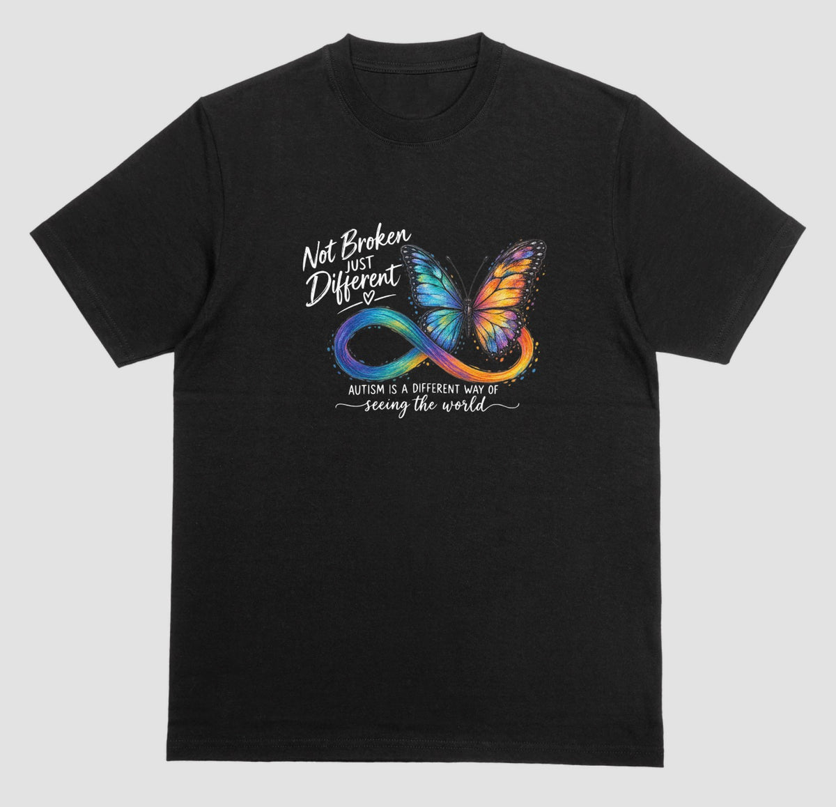 A black t-shirt with a colorful butterfly and rainbow infinity symbol, with the text ‘Not Broken, Just Different’ and ‘Autism is a different way of seeing the world.’