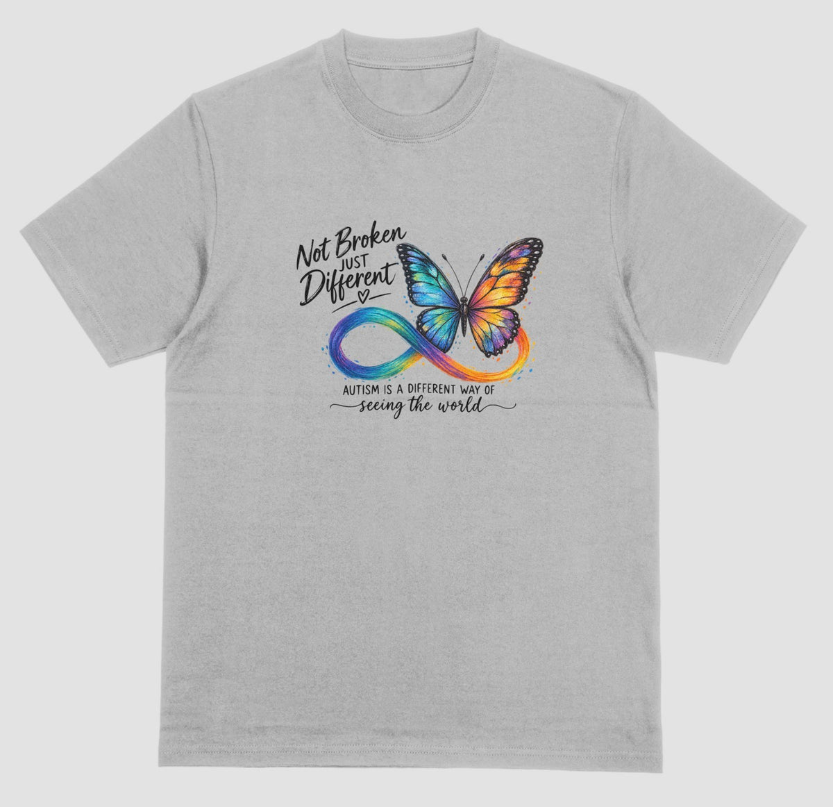 A grey t-shirt with a colorful butterfly and rainbow infinity symbol, with the text ‘Not Broken, Just Different’ and ‘Autism is a different way of seeing the world.’