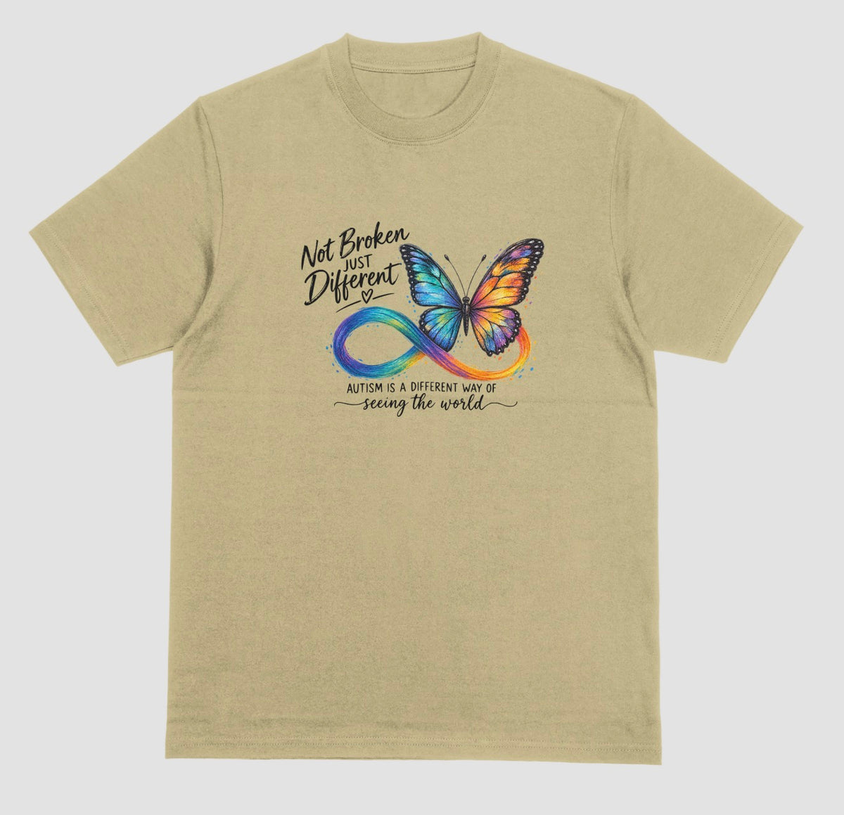 A sand color t-shirt with a colorful butterfly and rainbow infinity symbol, with the text ‘Not Broken, Just Different’ and ‘Autism is a different way of seeing the world.’