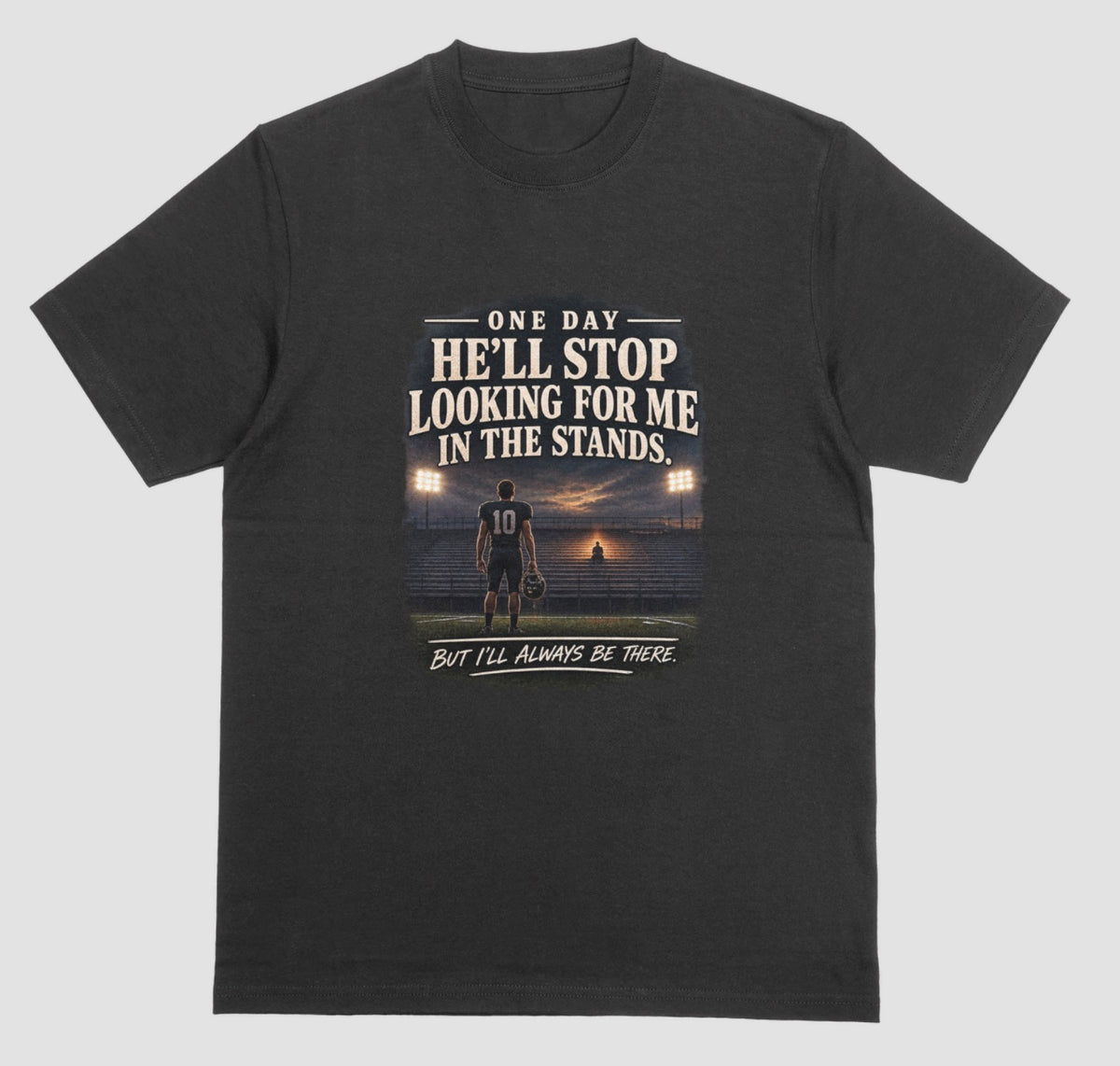 A black short-sleeve t-shirt with a graphic print on the front. The graphic features a football player on a field at sunset with the text 'ONE DAY HE'LL STOP LOOKING FOR ME IN THE STANDS.